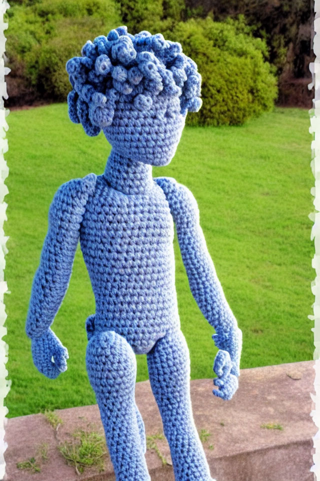 Knitted figure with curly blue head standing on brown ledge