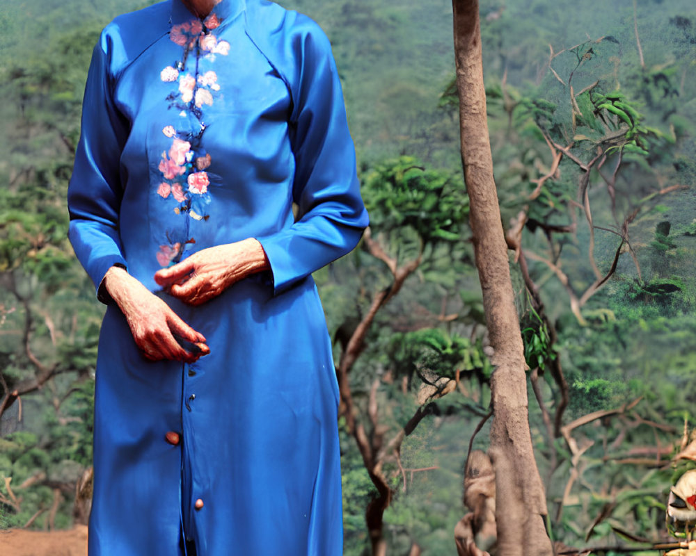 Elderly woman in blue floral dress outdoors with lush greenery and mountain