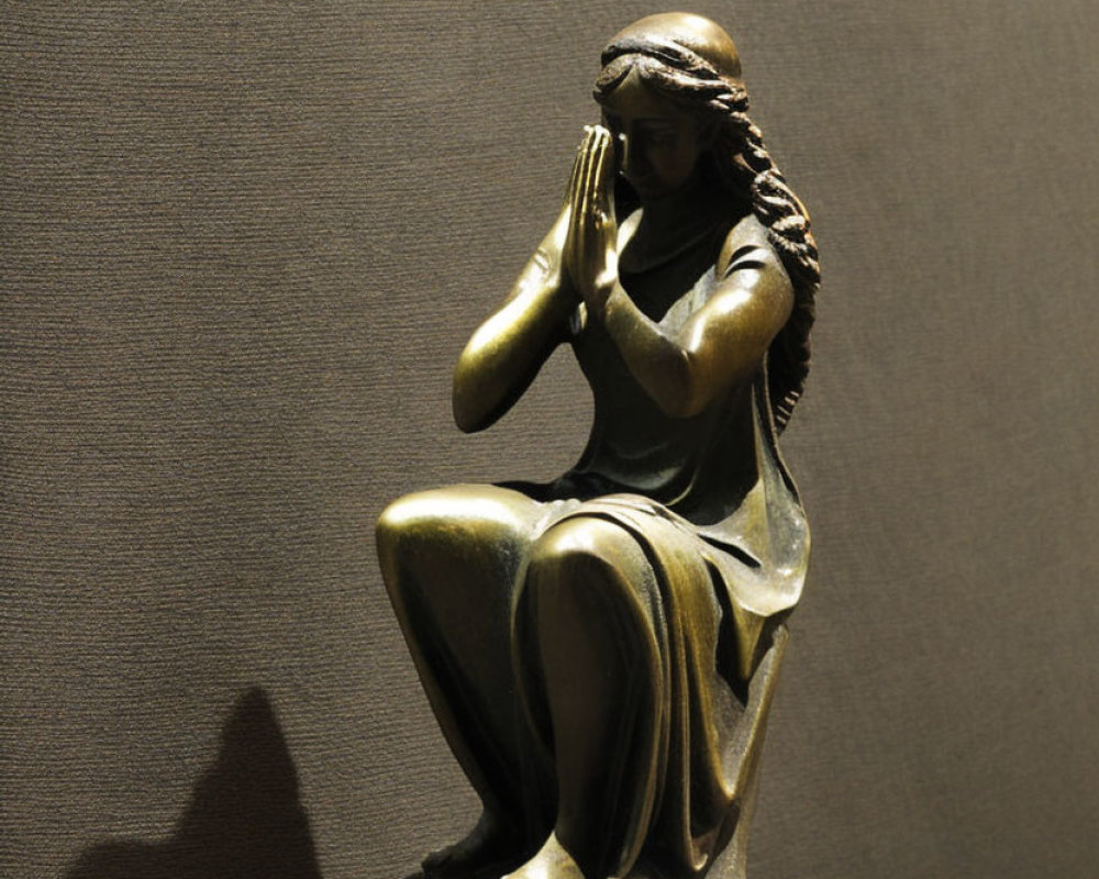 Bronze sculpture of seated female figure in prayerful pose