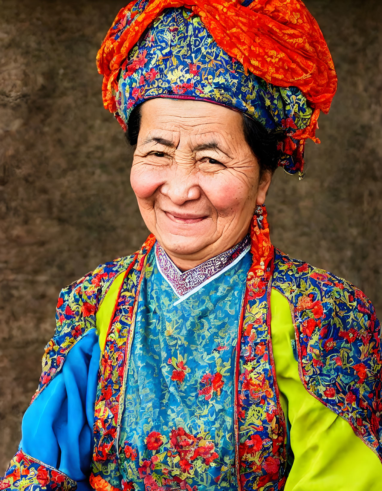 Elderly woman in blue and orange floral traditional outfit smiling