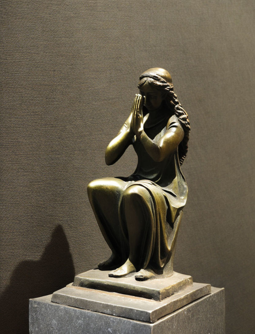 Bronze sculpture of seated female figure in prayerful pose