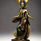 Golden Hindu deity statue with multiple arms and vibrant attire on pedestal