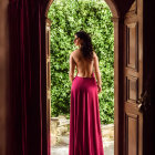 Woman in Burgundy Gown at Open Arched Doorway gazes at Lush Garden