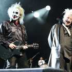 Clowns performing with guitar and singing on stage with drummer