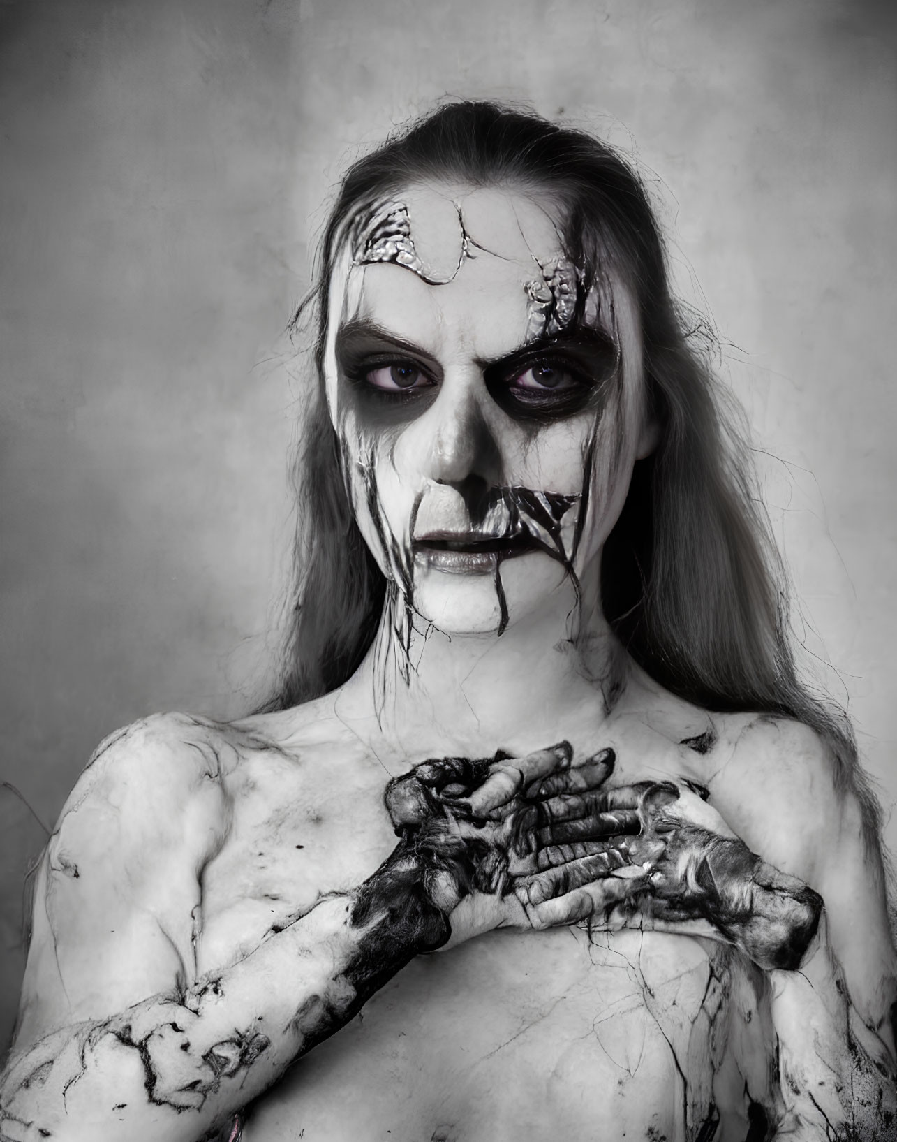 Intense stare with skull makeup and dark eyes against gray backdrop