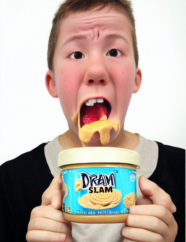 Young boy with peanut butter and "Dream Slam" jar on tongue.