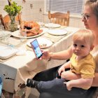 Woman and child at dining table in cozy kitchen scene.