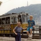 Children, robot, old bus, tarp-covered structure, aged street lamp in image