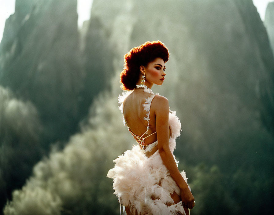 Elegant woman in feathered gown against misty mountains