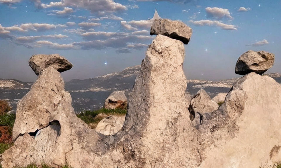 Natural rock formations under clear blue sky with distant mountains.