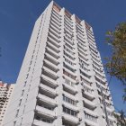 Stylized illustration of tall white building against swirling sky