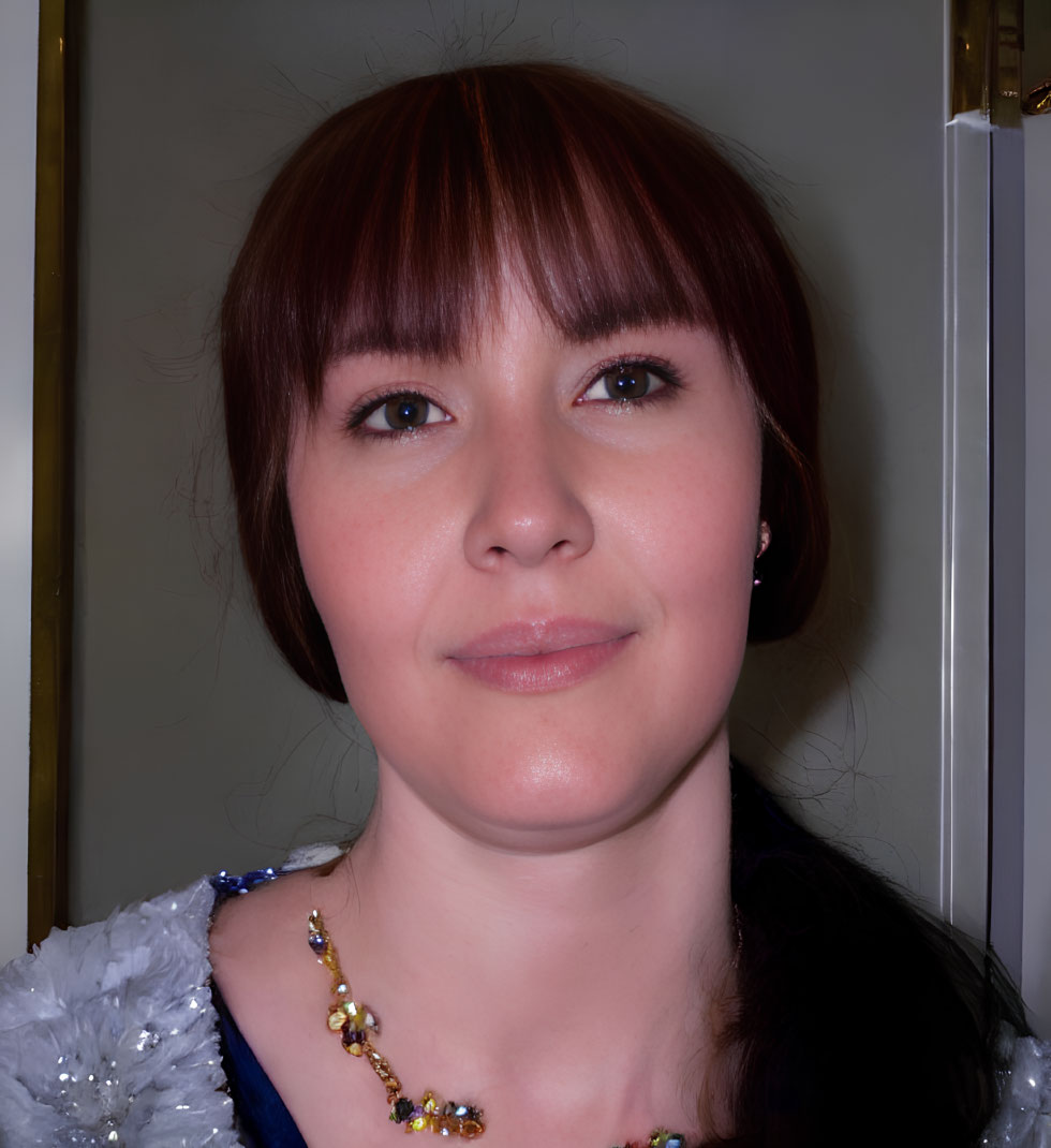 Auburn-Haired Woman in Blue Outfit with Colorful Necklace Smiles