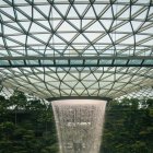 Indoor Waterfall Surrounded by Plants and Glass Ceiling