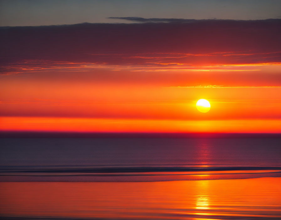 Scenic sunset with large sun over calm sea