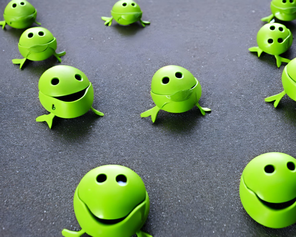 Green Smiling Toy Frogs on Dark Textured Surface