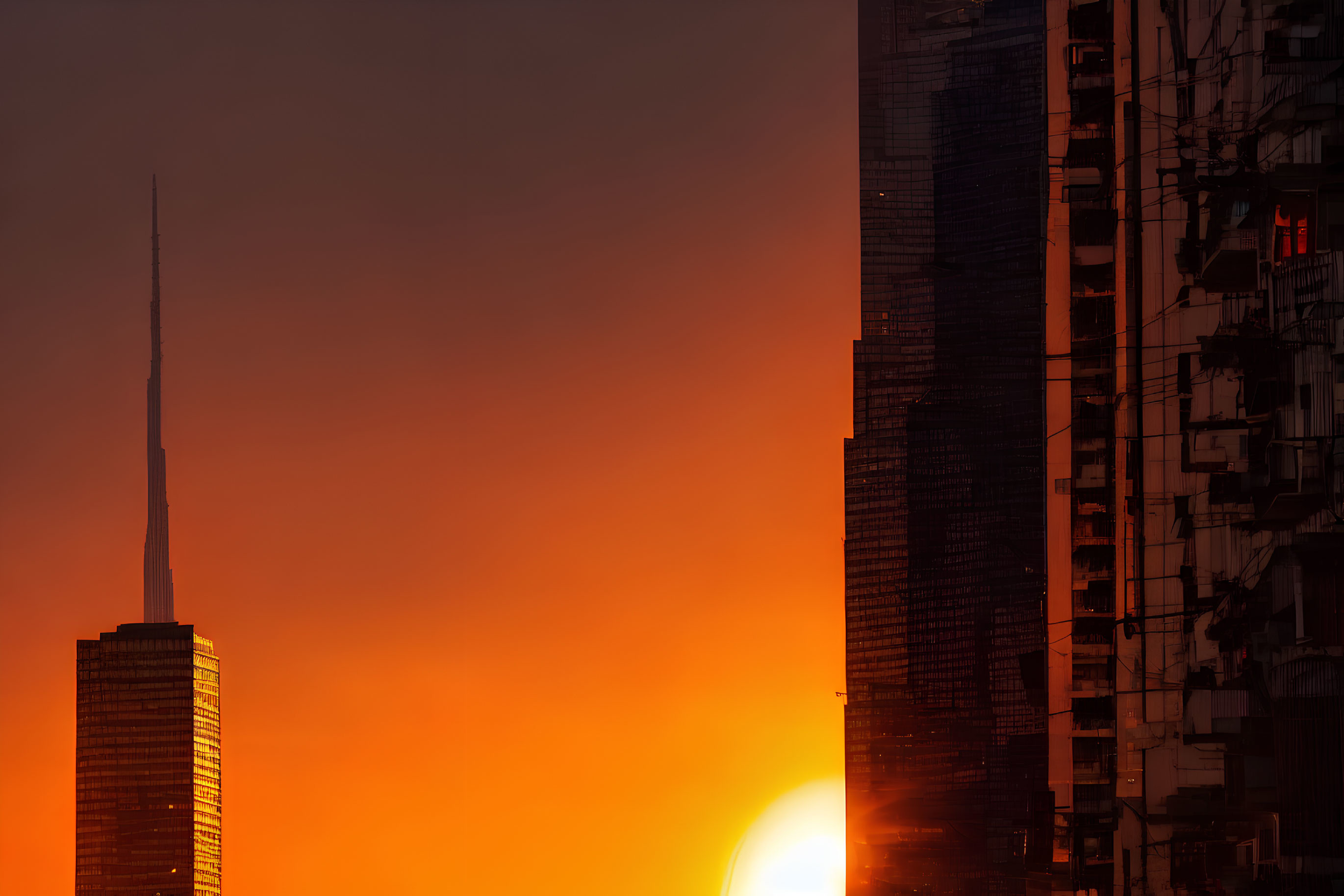 Urban Sunset: Silhouetted Skyscrapers Against Vibrant Orange Sky