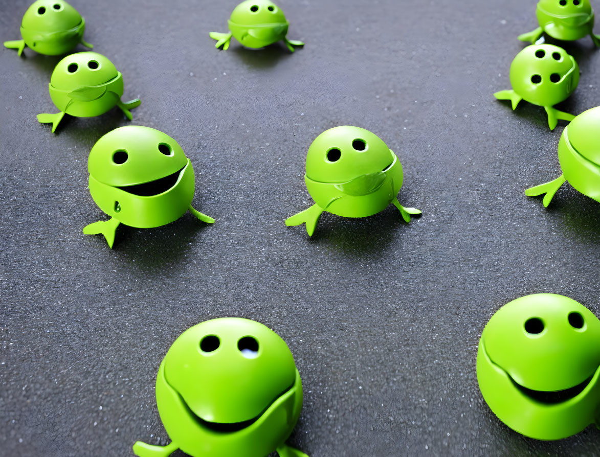 Green Smiling Toy Frogs on Dark Textured Surface