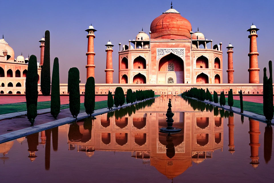 Symmetrical sunrise view of Taj Mahal with reflection in water