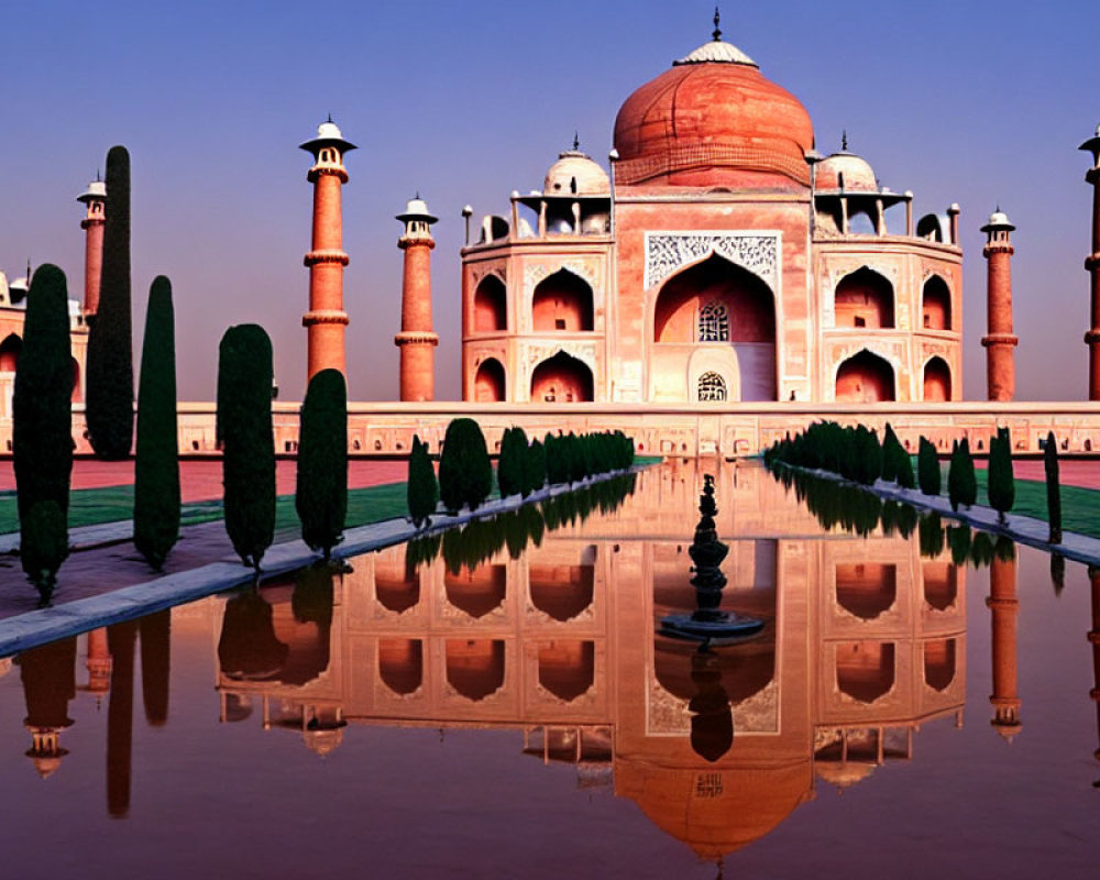 Symmetrical sunrise view of Taj Mahal with reflection in water