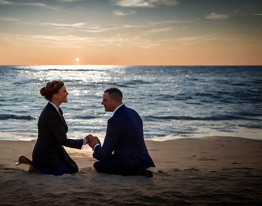 Couple holding hands on beach at sunset with ocean waves and clear sky