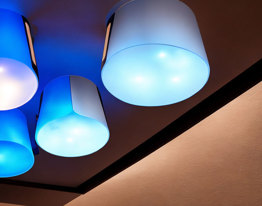 Three modern pendant lights casting a blue glow from the ceiling