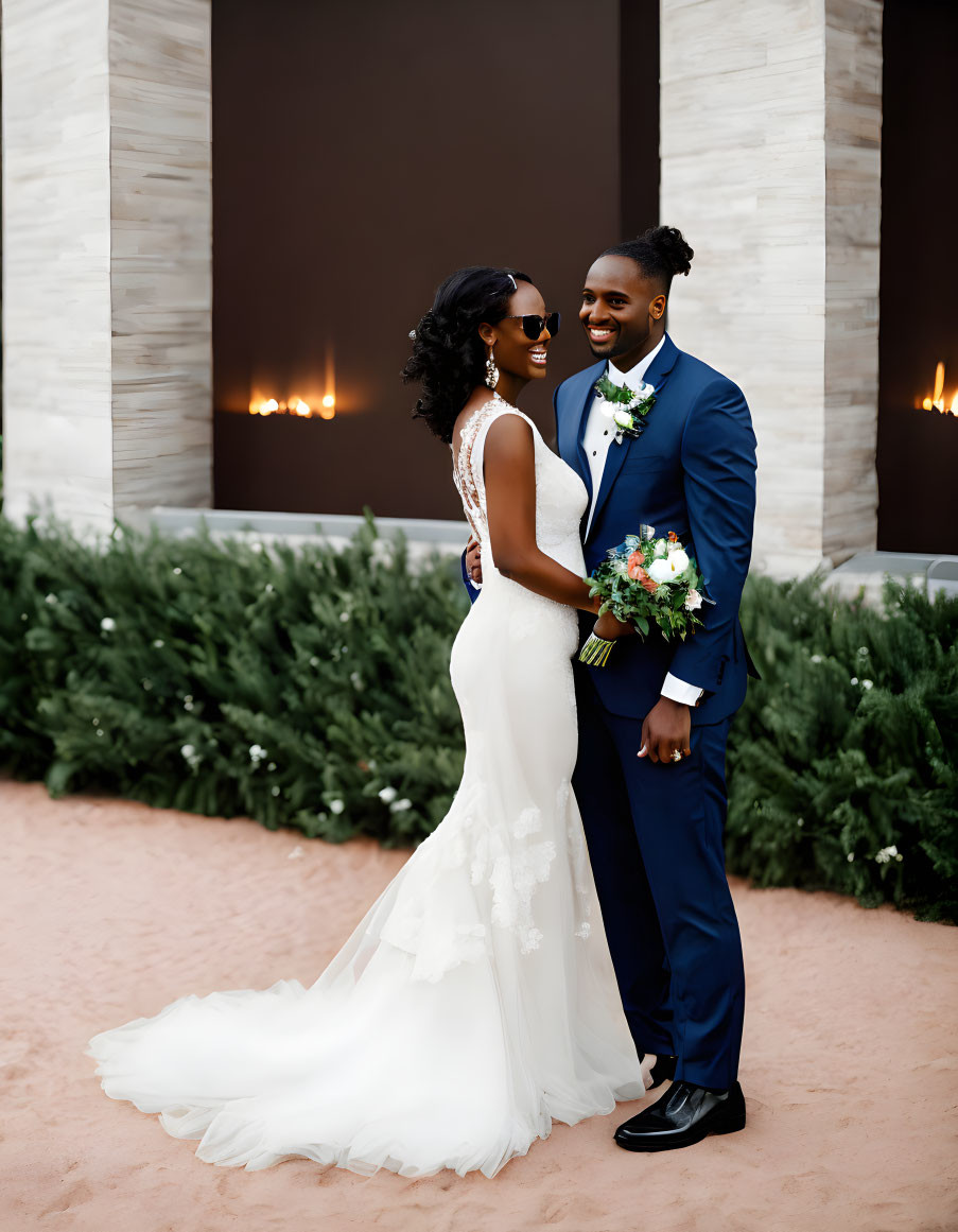 Smiling couple in white gown and blue suit outdoors