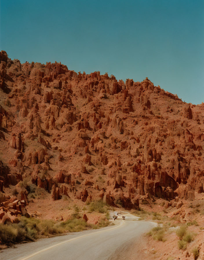 Winding Road in Reddish-Brown Rocky Desert Landscape