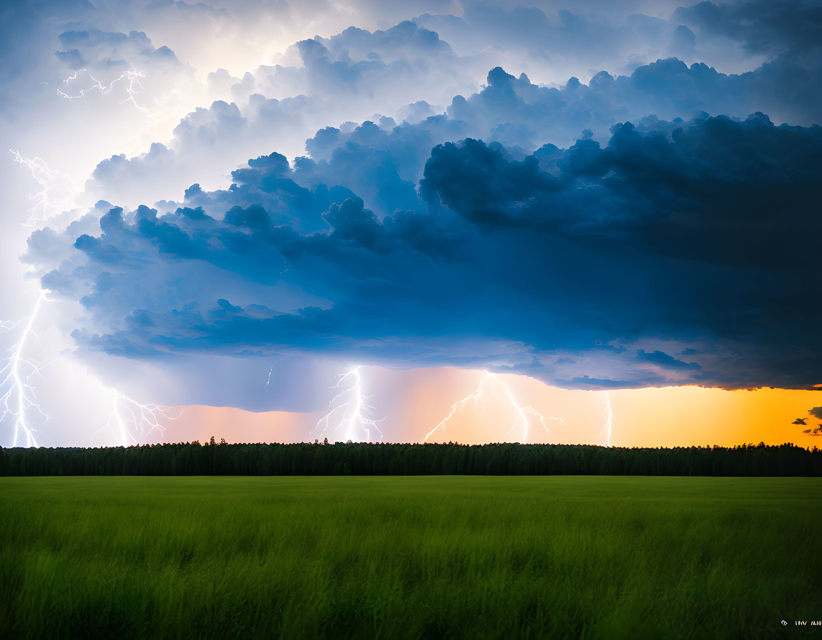 Dramatic landscape with dark thunderous clouds and lightning bolts over green field