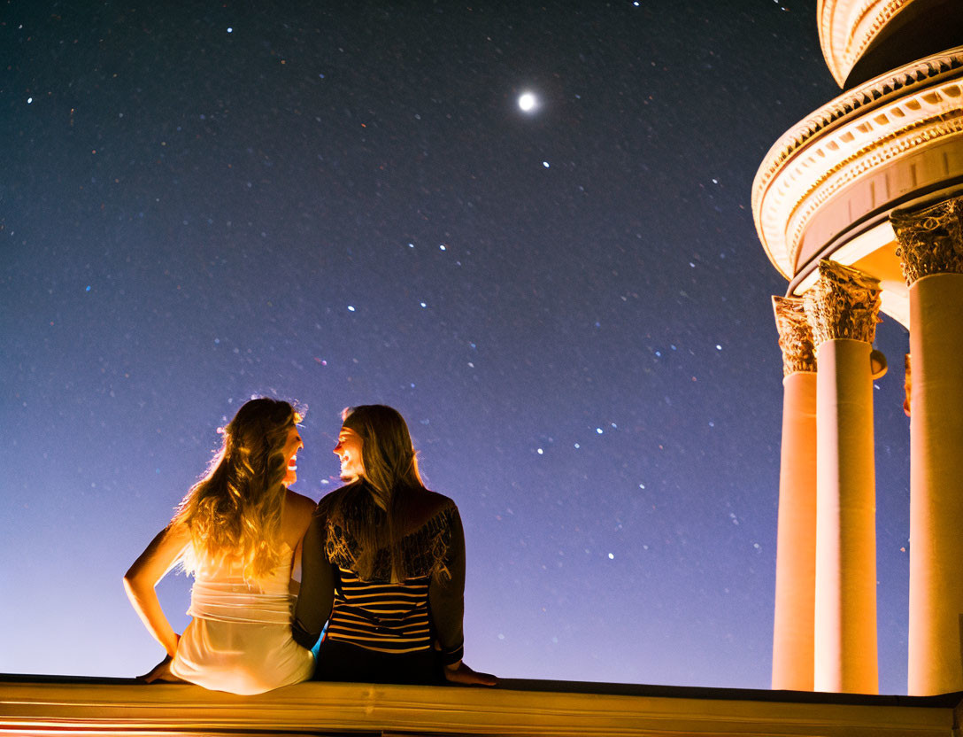 Silhouetted couple near ornate columns under star-filled night sky