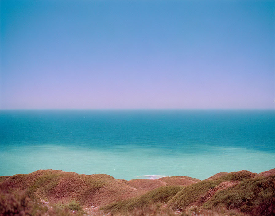 Tranquil Coastal Landscape with Blue Ocean and Green Hills