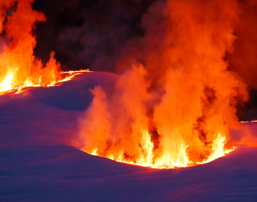 Intense flames on snowy field under twilight sky.