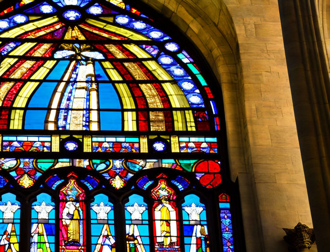 Colorful stained glass window with figures and patterns in a church stone arch