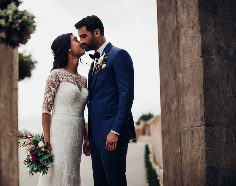 Elegant bride and groom share romantic moment by stone walls