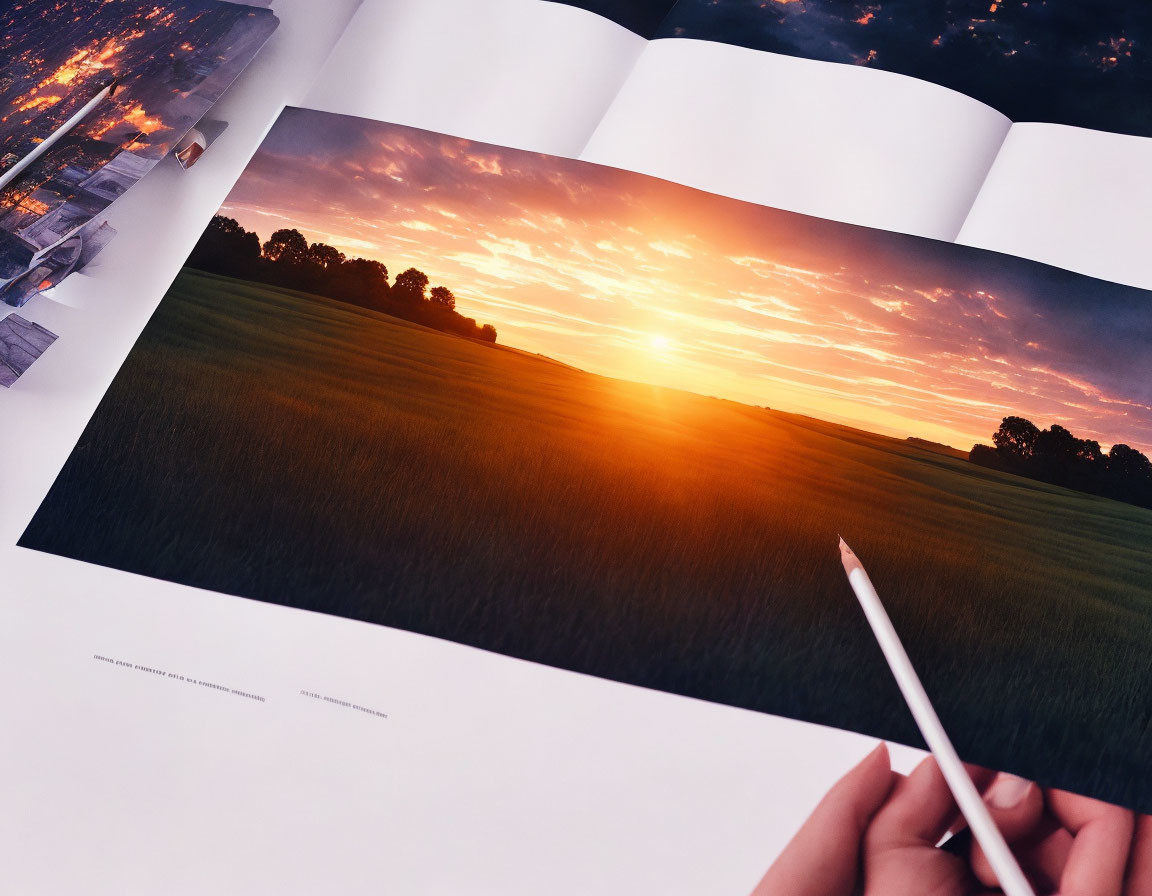 Landscape photograph of sunset over field in open book