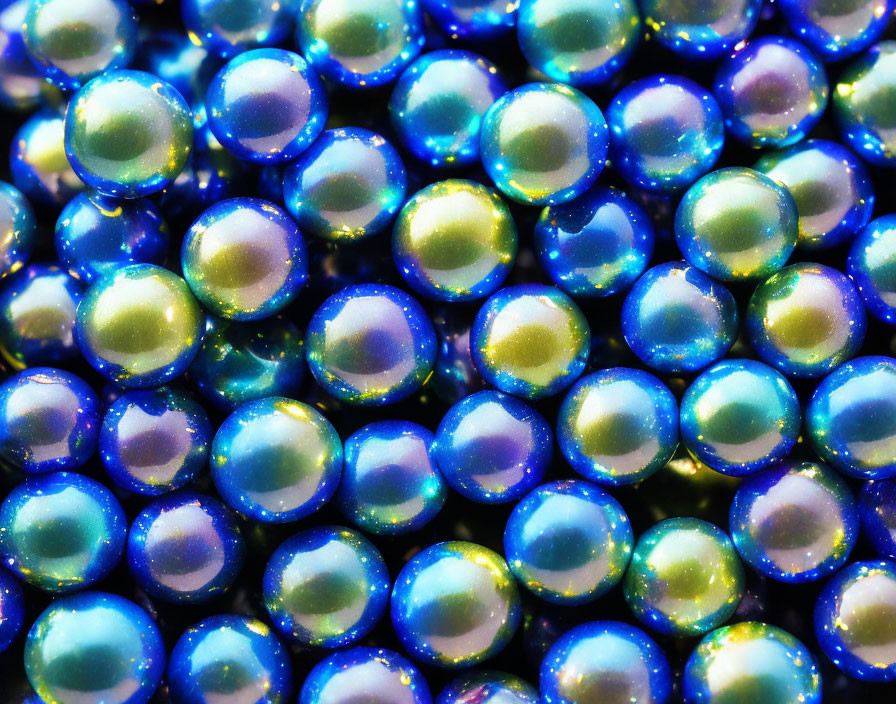 Colorful iridescent marbles in blue and green hues close-up