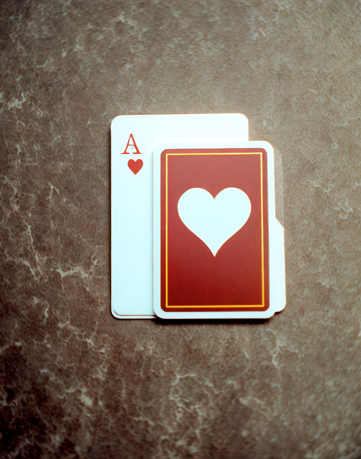 Ace of Hearts Card on Closed Deck of Playing Cards on Textured Surface