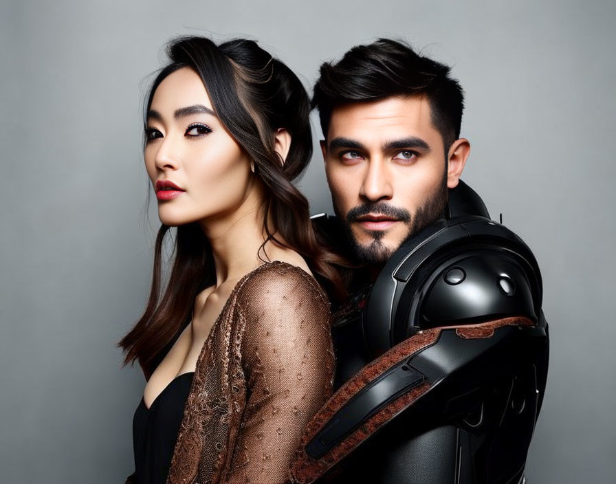 Woman with glamorous makeup and man with beard posing back-to-back with motorcycle helmet.