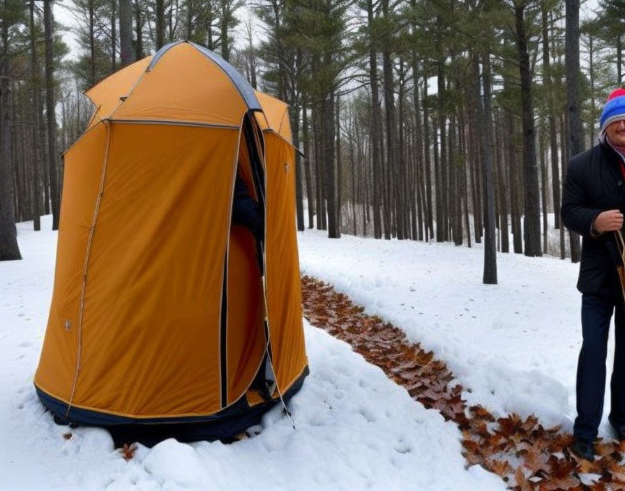 Winter camping scene with orange tent in snowy forest