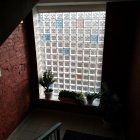 Colorful Glass Block Window in Staircase Landing with Plant & Tile Flooring