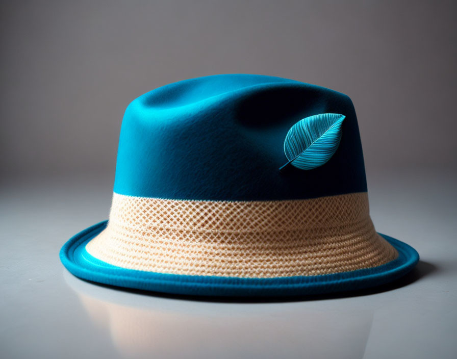 Blue Fedora Hat with Beige Band and Feather on Gray Background