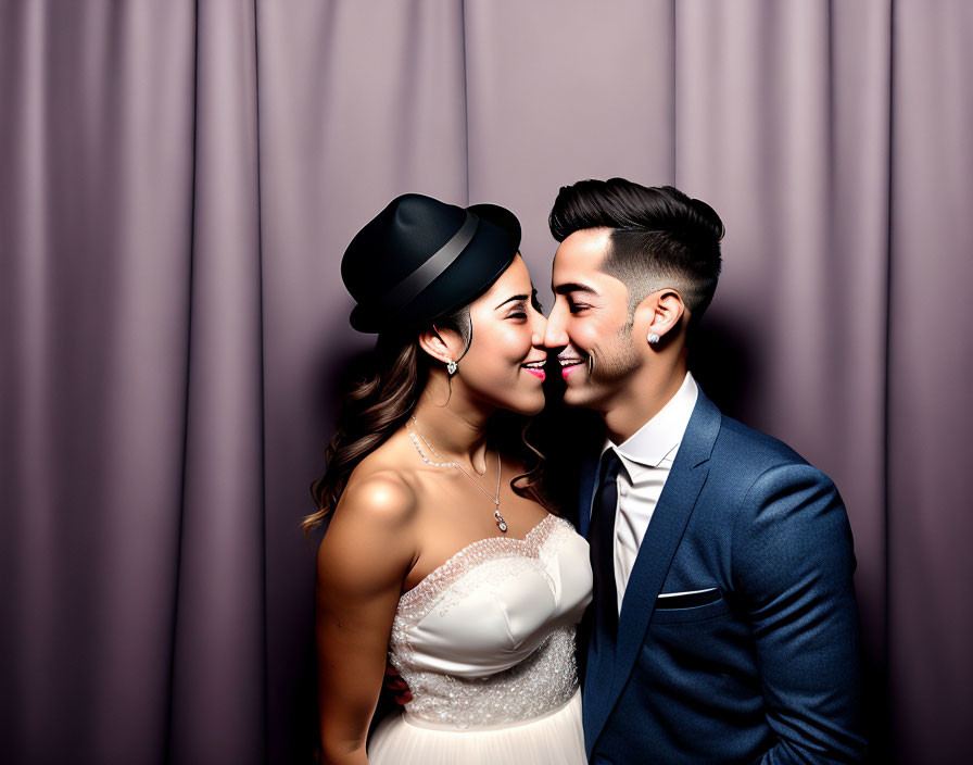 Smiling couple in white dress and suit against curtain backdrop