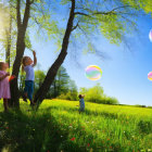 Kids playing with bubbles in sunny park with trees and blue sky.