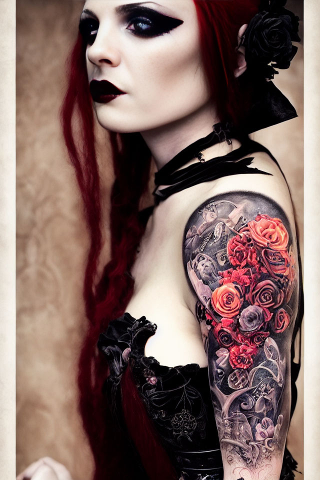 Red-haired person with dark makeup, black flower, and rose tattoo.