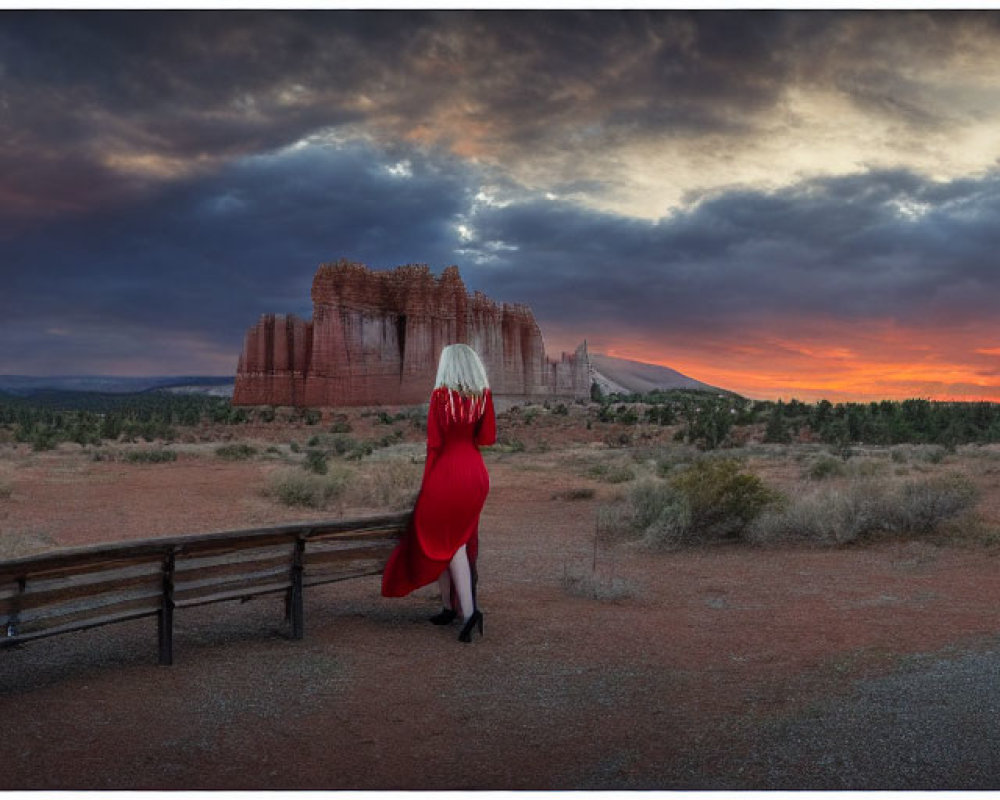 Person in red dress admiring sandstone landscape at sunset