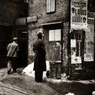 Vintage men by old car in snowy scene with gloomy background and dark house