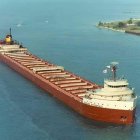 Large Red Ship Battles Turbulent Ocean Waves under Stormy Sky