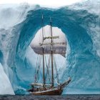 Surreal seascape with tall ships sailing amidst circular wave and cloudy sky