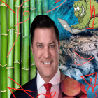 Man in suit with Asian dragon, bamboo background, face cracking to reveal skull.