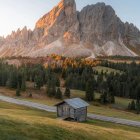 Vibrant sunset over mountain cabin in autumn landscape