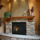 Warm Interior with Stone Fireplace, Wooden Details, Lanterns, Candles, and Plants